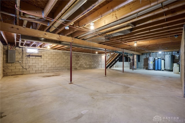 basement featuring electric panel and water heater