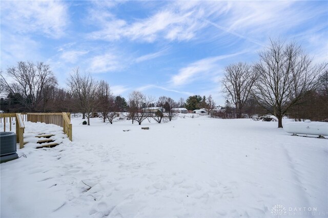 yard layered in snow featuring central air condition unit