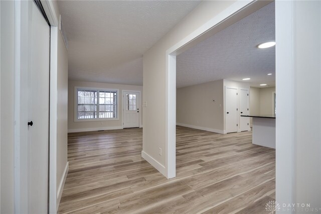 interior space with light wood-type flooring and a textured ceiling