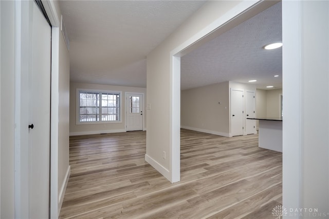 interior space with a textured ceiling and light wood-type flooring