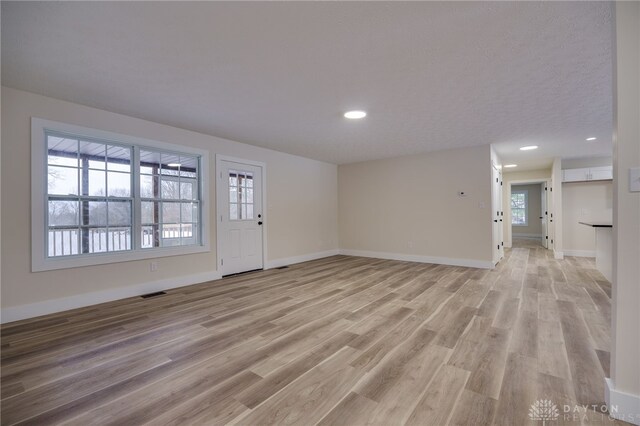 interior space with plenty of natural light and light hardwood / wood-style flooring