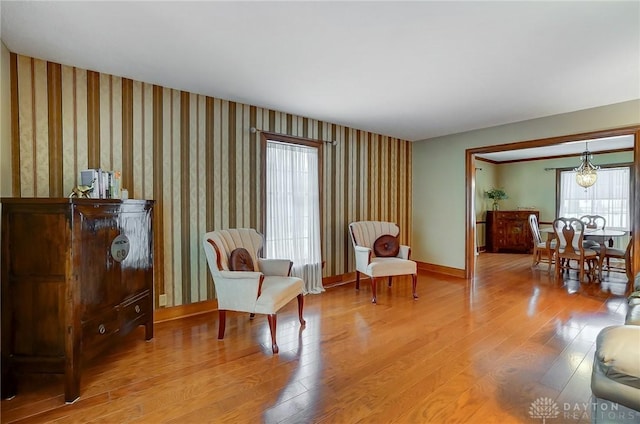 living area with light hardwood / wood-style floors and a notable chandelier