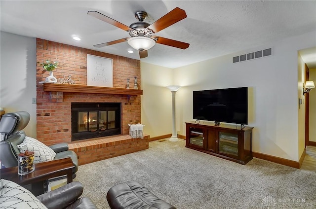 carpeted living room with a brick fireplace and ceiling fan