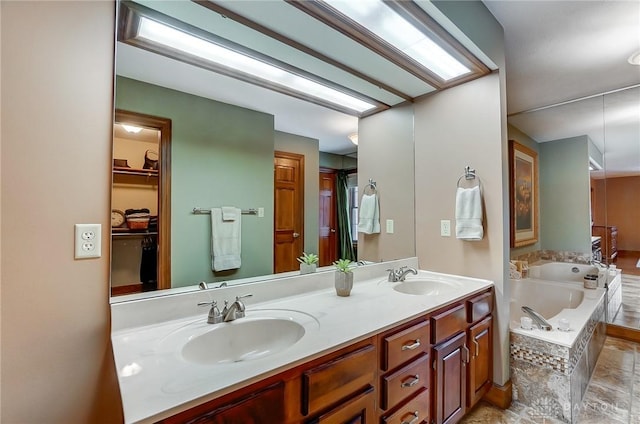 bathroom featuring tiled tub and vanity