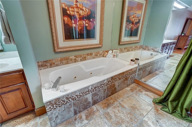 bathroom with tiled bath and vanity