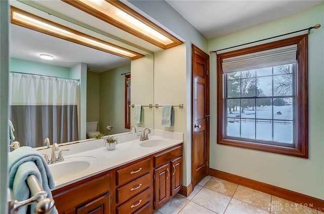 bathroom featuring toilet, tile patterned flooring, and vanity