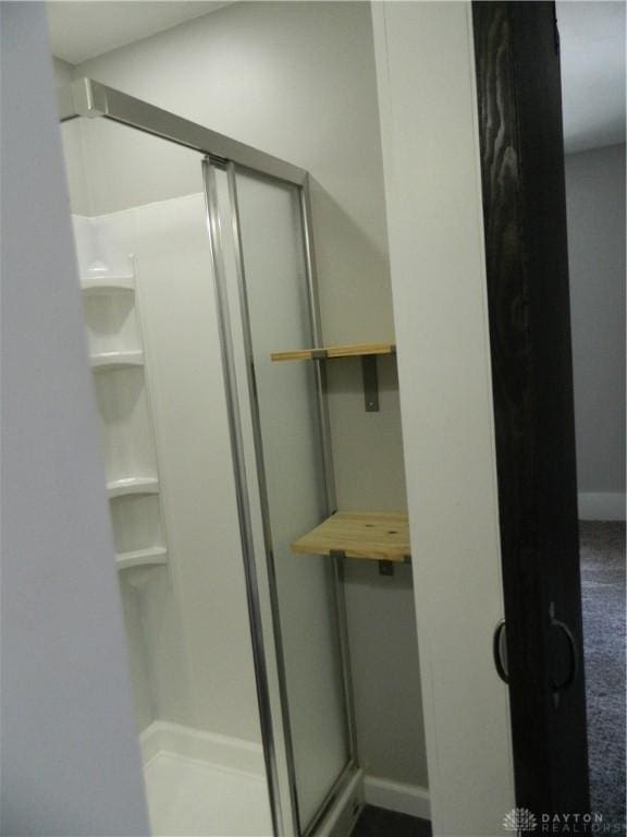 bathroom with a shower with door