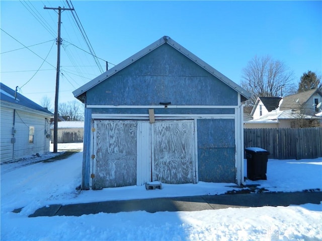 snow covered property featuring an outdoor structure