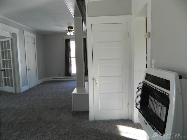 interior space featuring a baseboard heating unit, ceiling fan, dark carpet, and heating unit