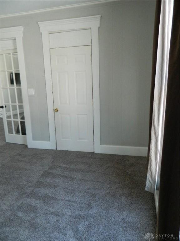 unfurnished room with dark carpet