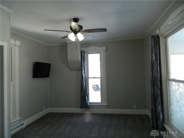 spare room with ceiling fan, crown molding, and dark carpet