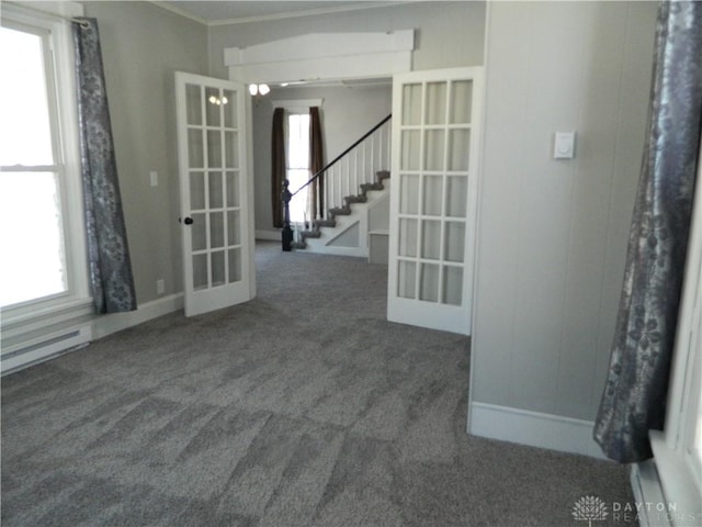 carpeted spare room with french doors and a healthy amount of sunlight