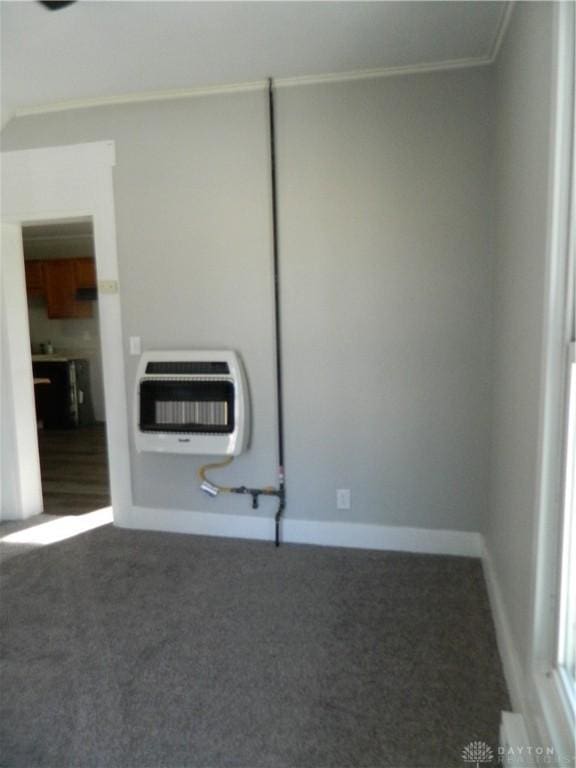 carpeted empty room featuring crown molding and heating unit