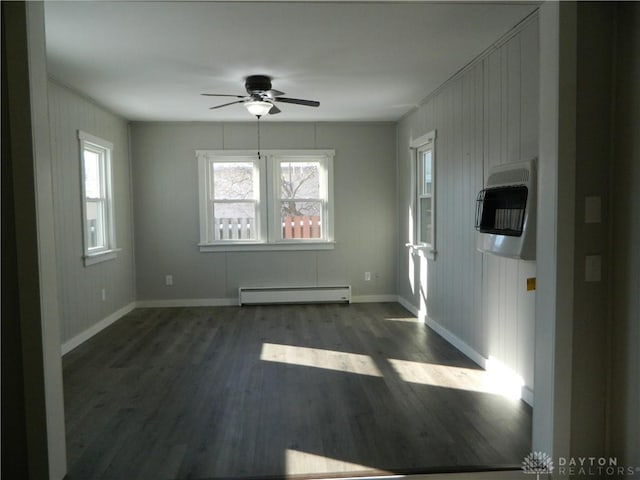 unfurnished room with ceiling fan, dark wood-type flooring, heating unit, and a baseboard radiator