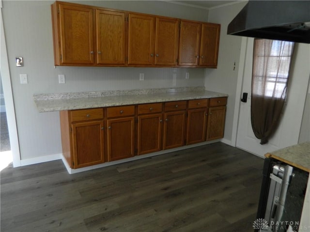 kitchen with dark hardwood / wood-style flooring and crown molding