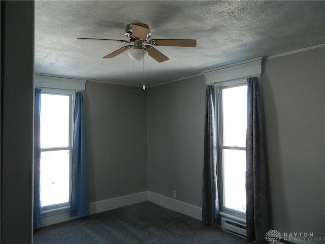 carpeted empty room with a healthy amount of sunlight, ceiling fan, and a textured ceiling