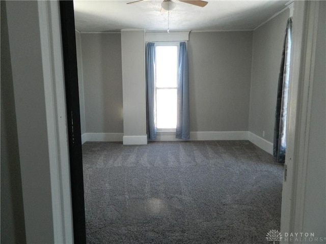 carpeted spare room with ceiling fan and ornamental molding