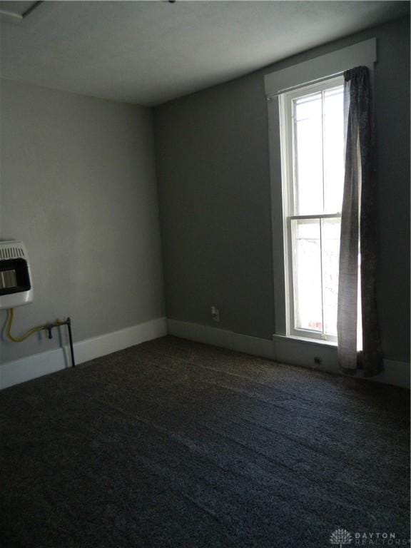 carpeted empty room with heating unit