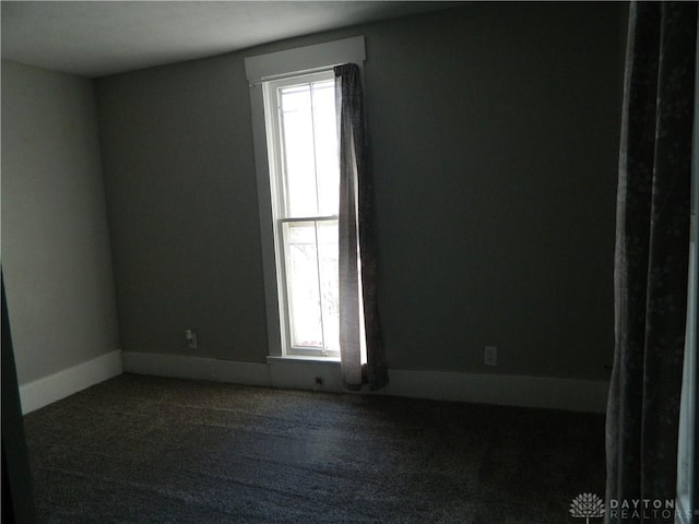 empty room featuring dark carpet