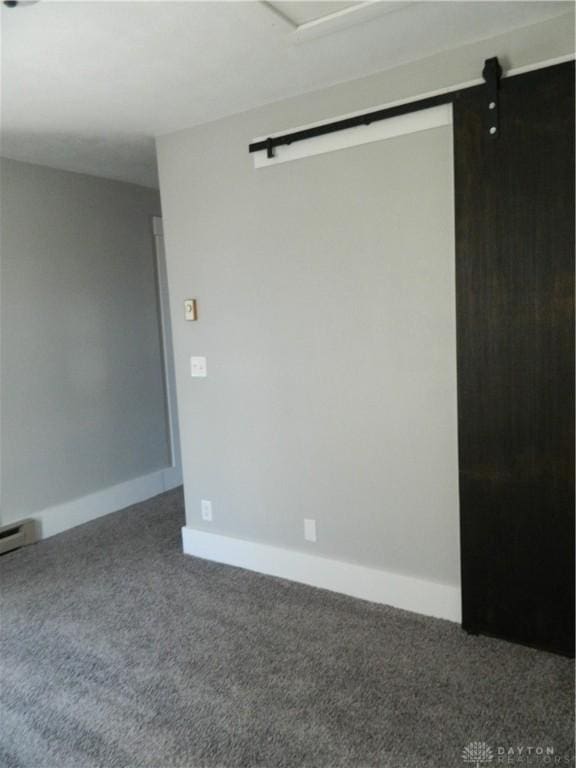 empty room featuring carpet and a barn door