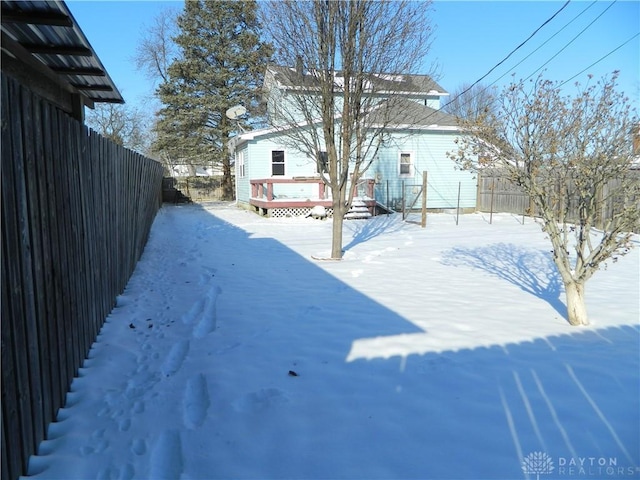 yard covered in snow with a deck