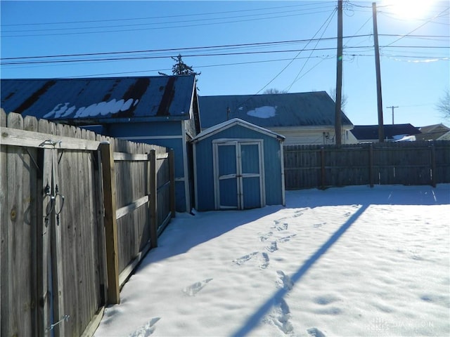 snowy yard featuring a shed