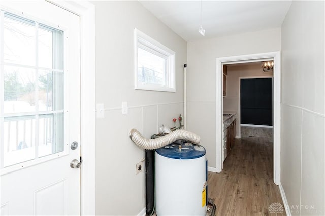 bathroom with electric water heater, a healthy amount of sunlight, and hardwood / wood-style floors