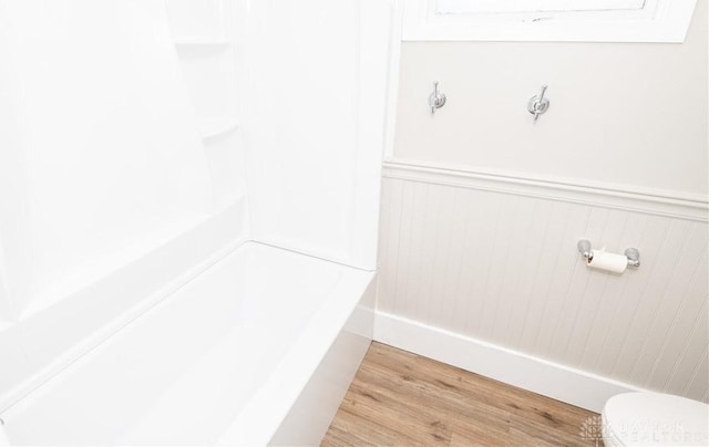 bathroom featuring toilet, walk in shower, and hardwood / wood-style flooring