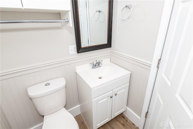 bathroom featuring toilet, hardwood / wood-style flooring, and vanity