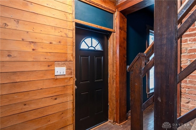 foyer entrance featuring wooden walls and hardwood / wood-style floors