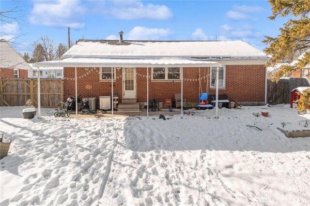 view of snow covered back of property