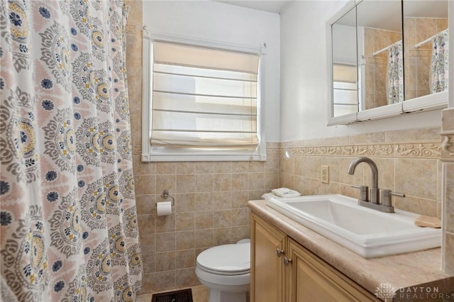 bathroom featuring tile walls, vanity, toilet, and a shower with shower curtain