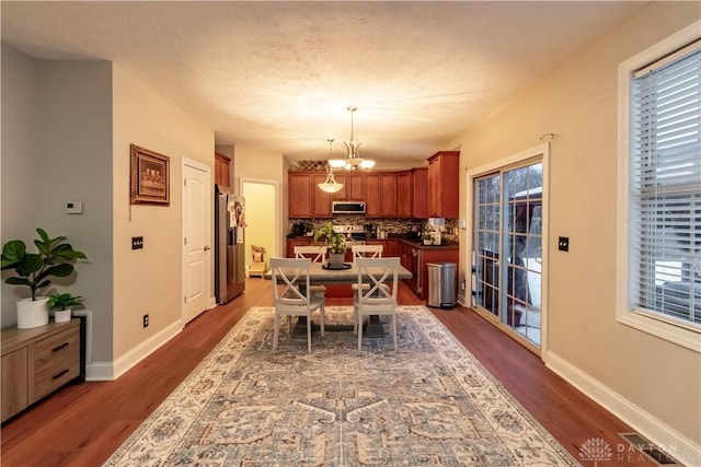 dining room featuring dark wood-type flooring and a notable chandelier