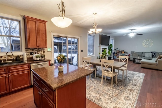 kitchen with sink, decorative light fixtures, a center island, ceiling fan with notable chandelier, and decorative backsplash