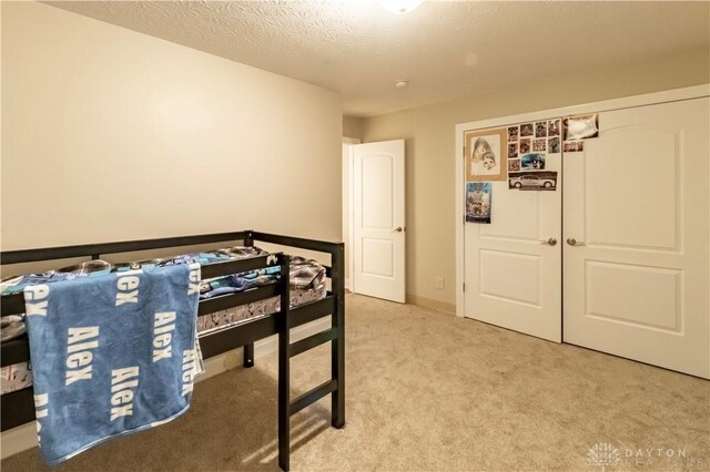 bedroom with a textured ceiling and carpet flooring