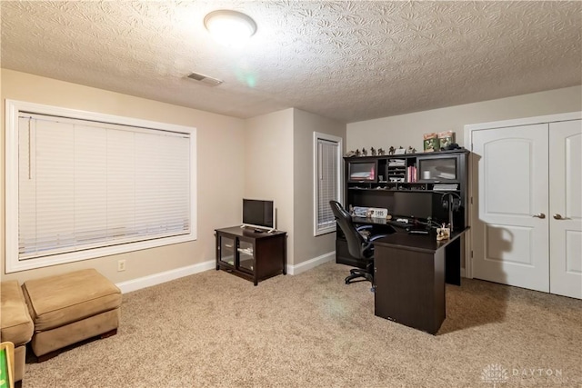 carpeted office with a textured ceiling