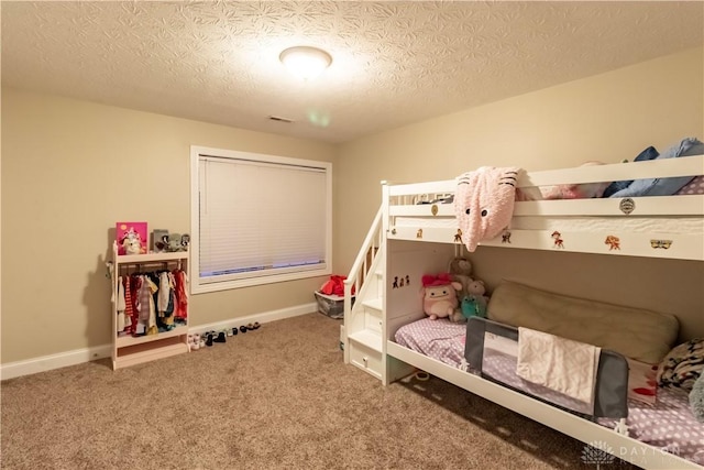 bedroom featuring a textured ceiling and carpet flooring