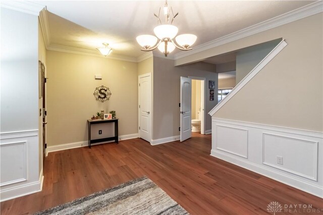 interior space featuring a chandelier, crown molding, and dark wood-type flooring