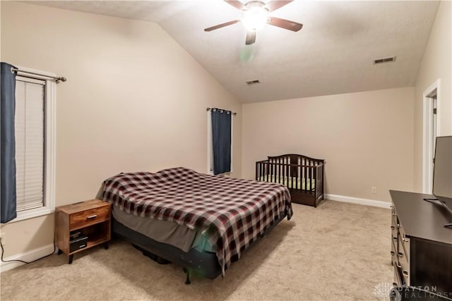 bedroom with ceiling fan, light colored carpet, and vaulted ceiling