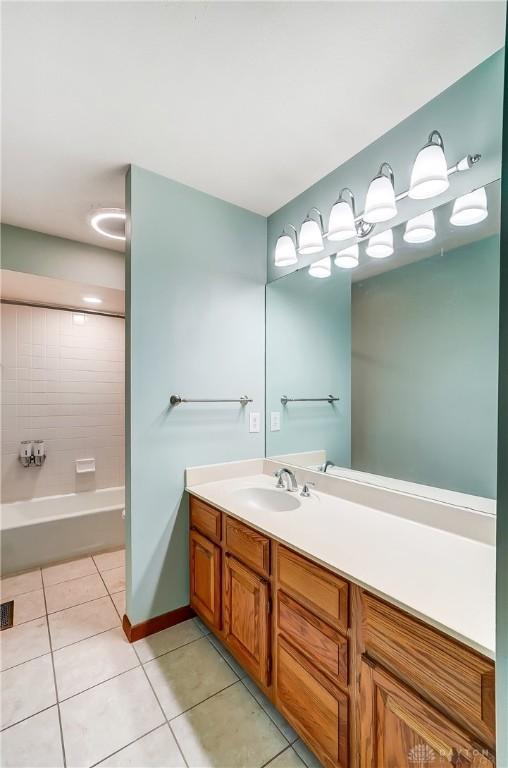 bathroom with tiled shower / bath, tile patterned floors, and vanity