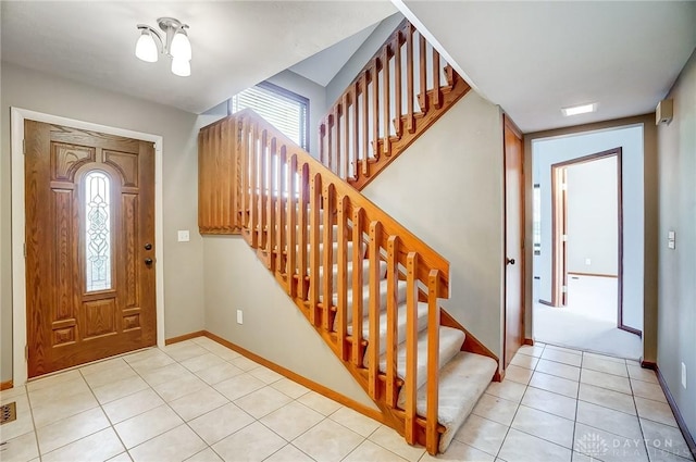 tiled entryway featuring an inviting chandelier