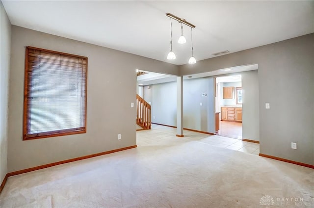 spare room with track lighting and light carpet