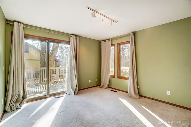 unfurnished room with light colored carpet and track lighting