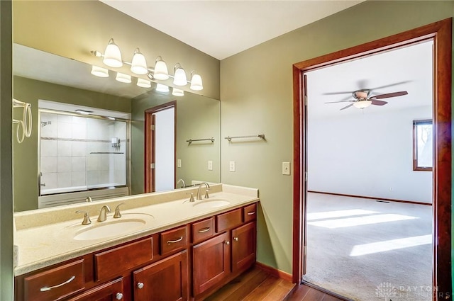 bathroom with ceiling fan, tiled shower, hardwood / wood-style floors, and vanity