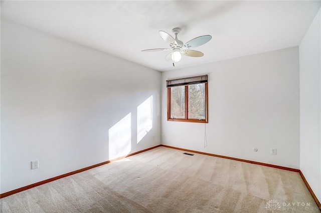 spare room with ceiling fan and light colored carpet