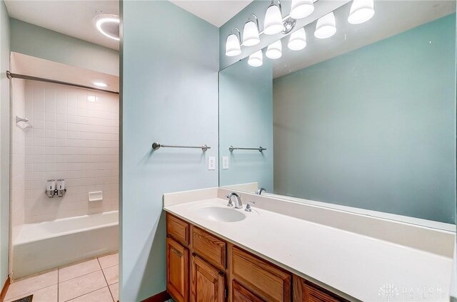 bathroom featuring tiled shower / bath, tile patterned floors, and vanity