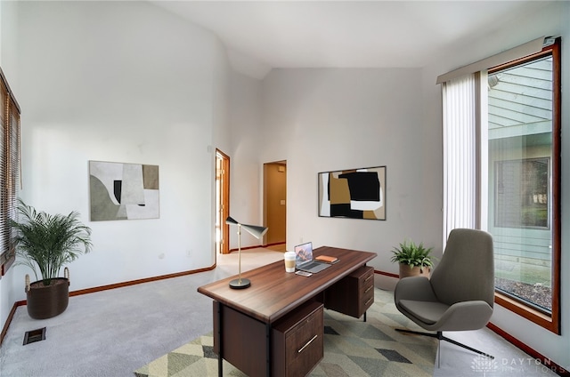 carpeted office with lofted ceiling