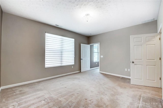 carpeted spare room with a textured ceiling