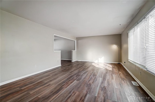 empty room with dark hardwood / wood-style flooring