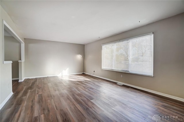 empty room with dark wood-type flooring